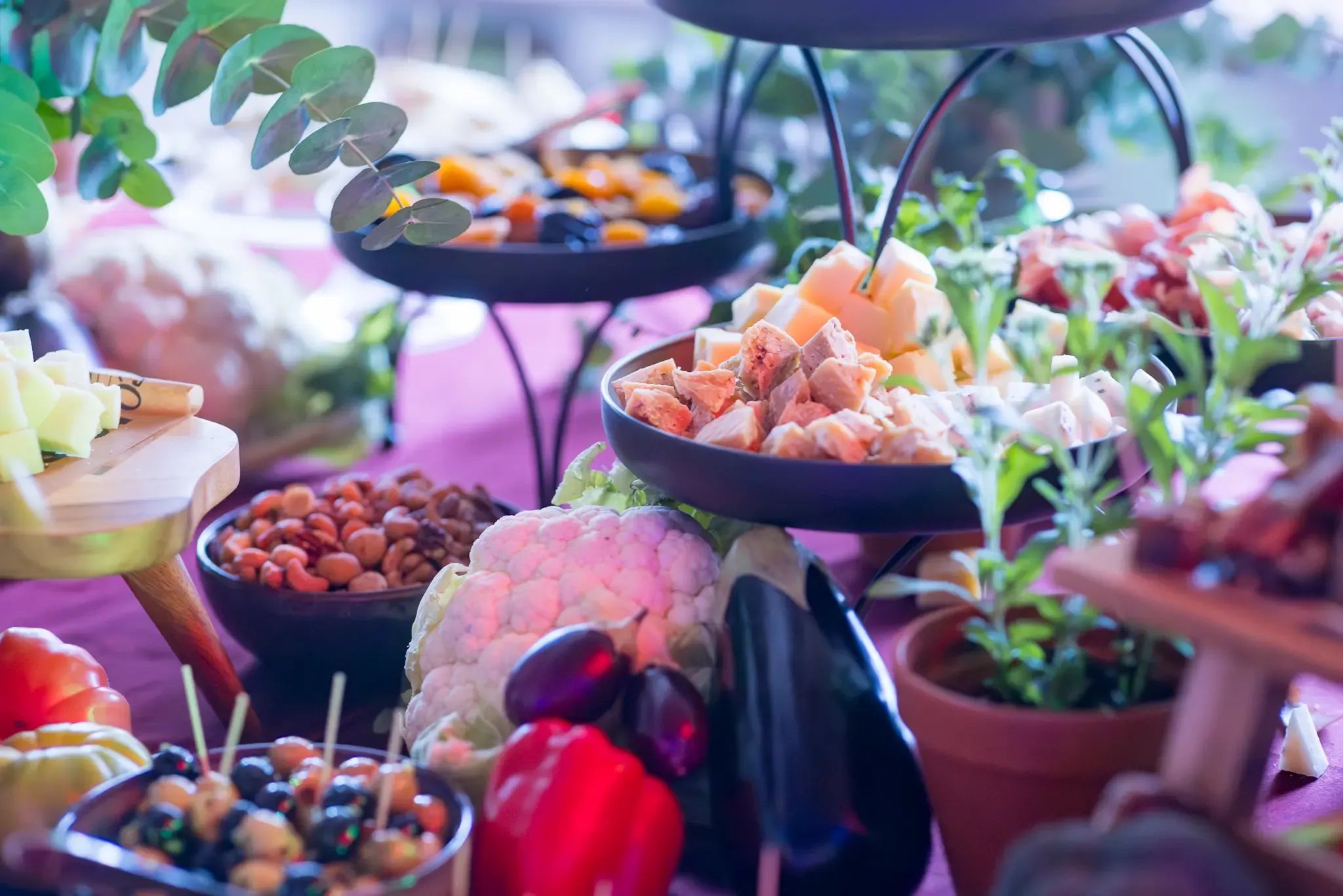 Een kleurrijke buffettafel vol met noten, gedroogd fruit, kaas, groenten en kleine hapjes.